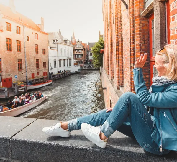 passeio de barco pelos canais de Bruges com turistas