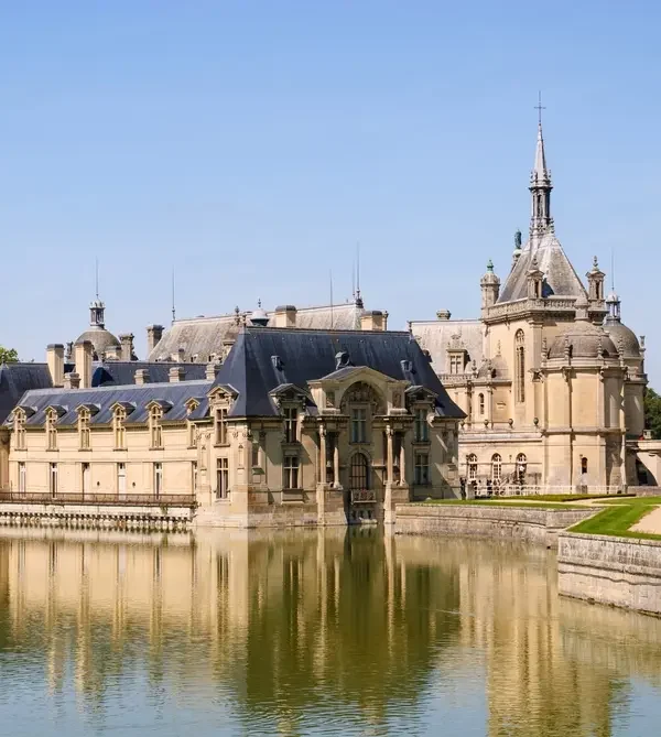 castelo de Chantilly visto de frente com reflexo no espelho d'água
