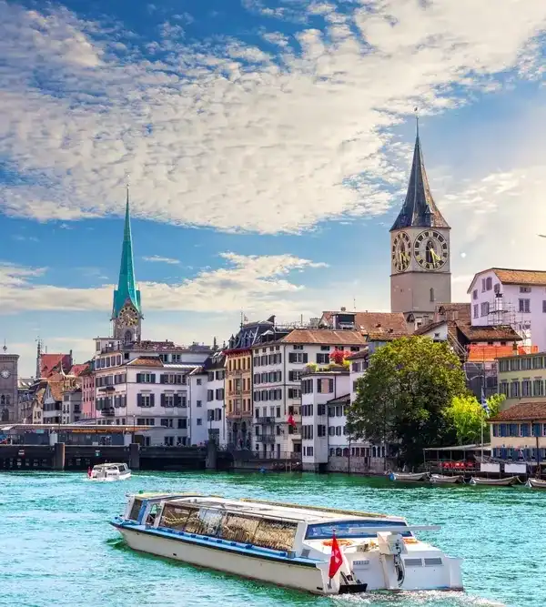 Vistas da cidade de Zurich, com rio e barcos navegando, destacando o charme europeu e a elegância na Suíça.