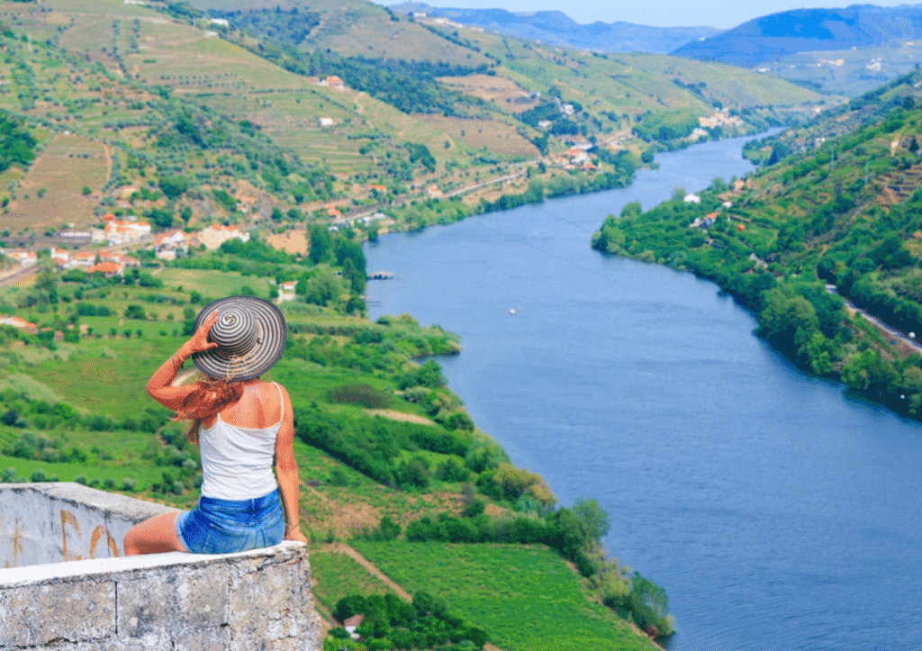 Scenic boat tour on the Douro River with vineyards along the hillsides in northern Portugal.